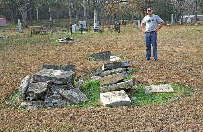 Figure 4. James Starnes standing behind the ruins of a box-grave monument in the old Raymond cemetery made from Catahoula sandstone quarried at Mississippi Springs. Picture (color negative 603-21) taken on December 19, 2006.