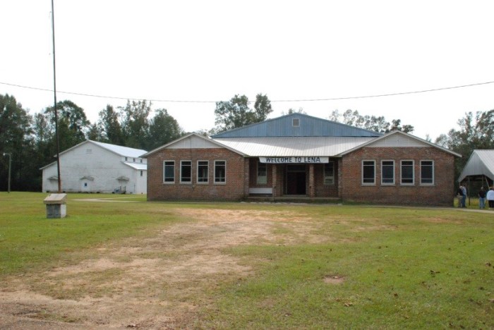 Lena School and Gym, Lena, Leake County. Lena School (1928) and Gym (c.1940) is historically significant as an intact consolidated school campus from the interwar period. Lena Consolidated School anchored the rural community of Lena for a half century after it opened in 1918. The consolidated school took the place of the previous county agricultural high school, a boarding institution, as a more practical, less expensive way to deliver a high school education to rural children, bussing children first in buggies and then in 1925 in trucks from the surrounding farms. The high school moved to South Leake High School during integration in January 1970, and the elementary also closed in the 1980s. Vocational buildings, teachers’ houses, and gymnasiums were common additions to consolidated campuses through the 1930s and 1940s, and the Lena campus, lacking only its non-extant vocational building, stands as a good example of this educational village, which was considered a Progressive way of educating rural children. Architectural The gymnasium, a vanishing breed of frame pre-World War II gyms in the state, is the more architecturally significant building of the two under consideration for Mississippi Landmark designation. The Mississippi Department of Education produced a series of standard plans for a variety of school buildings including gyms, and Lena’s appears to be Plan #GM-7, a popular plan around the state but rare today because of the wood construction.